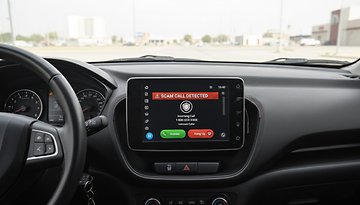 Car dashboard displaying a warning for a scam call detected on Android Auto.