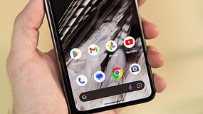 Eine Hand hält ein Smartphone, das Google Chrome und verschiedene App-Icons zeigt.