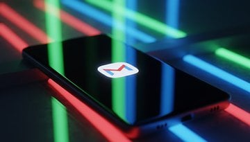A smartphone displaying the Gmail logo, surrounded by colorful neon lights.