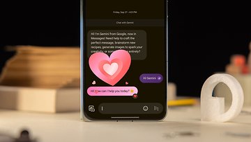 Ein Smartphone zeigt einen Chat in Google Messages mit einer Begrüßung und Herz-Emojis.