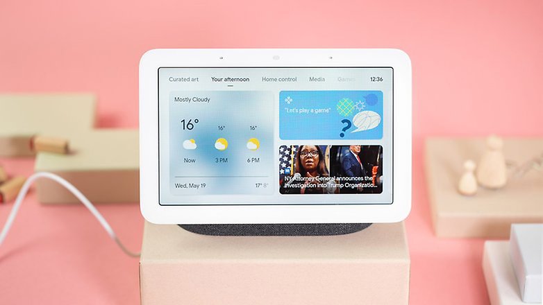 Ein Google Nest Hub 2, der Wetter- und Nachrichtenupdates auf einem rosa Hintergrund anzeigt. Ein Google Nest Hub 2, der Wetter- und Nachrichtenupdates auf einem rosa Hintergrund anzeigt.