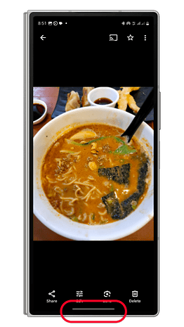 Un smartphone Samsung affichant un bol de ramen avec bouillon, nouilles et garnitures.