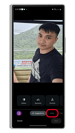 Seseorang yang mengambil selfie dengan pemandangan gunung di latar belakang, pilihan penyuntingan yang dipaparkan pada skrin telefon.