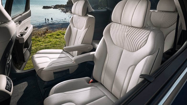 Interior view of a Hyundai Palisade 2020 with white leather seats and a scenic background.