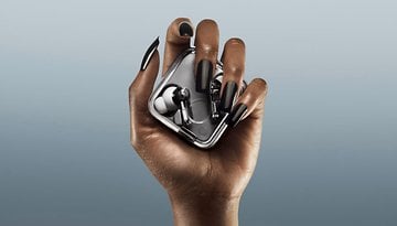 A hand holding the Nothing Ear 3 earbuds in their case, showcasing sleek design.