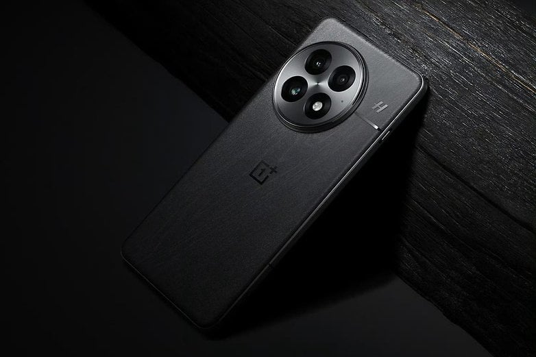 En OnePlus 13-smarttelefon som ligger på en mörk träyta och visar upp sin eleganta design och tredubbla kamerainställningar.