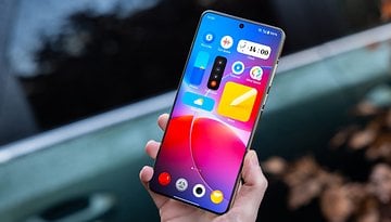 A person holding a OnePlus 13 smartphone displaying a colorful home screen.