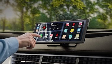 A hand interacting with an Ottocast touchscreen display in a car, showing various app options.