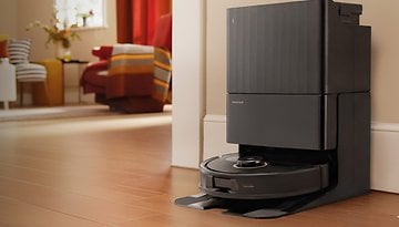 Roborock Qrevo S5V robot vacuum mop with self-wash dock in a modern living room.