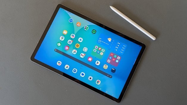 A Samsung Galaxy Tab S10 FE tablet displayed with various app icons on the screen and a stylus beside it.