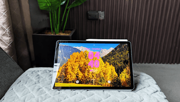 Samsung Galaxy Tab S10 FE displaying a scenic mountain and autumn trees wallpaper with the time 04:40.