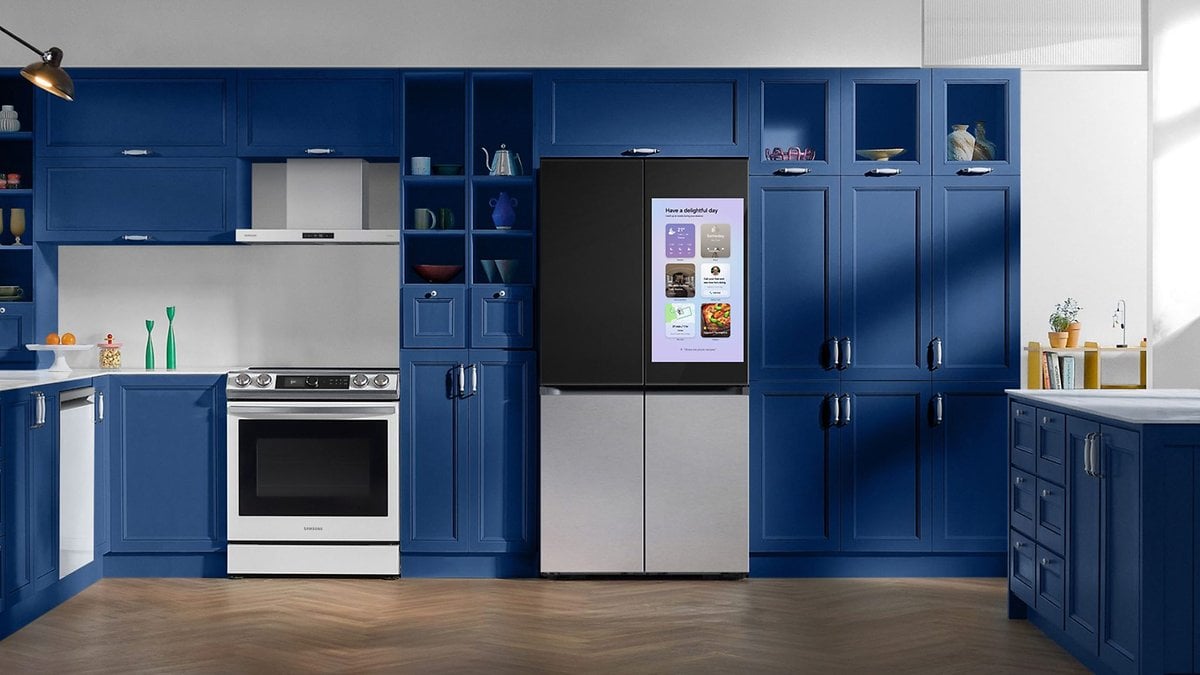 Une cuisine moderne avec un réfrigérateur Samsung à écran, des armoires bleues et un four en acier inoxydable.