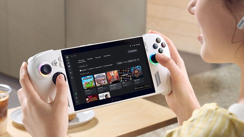 Uma pessoa segura um dispositivo de jogo mostrando a interface do Xbox com opções de jogos. Uma pessoa segura um dispositivo de jogo mostrando a interface do Xbox com opções de jogos.
