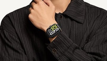 A hand wearing a Xiaomi Redmi Watch 5, displaying yellow and white digital numbers.