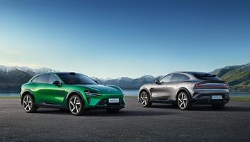 Zwei Autos, eines grün und eines grau, geparkt vor einer malerischen Bergkulisse mit dem Text 'Xiaomi YU7'.