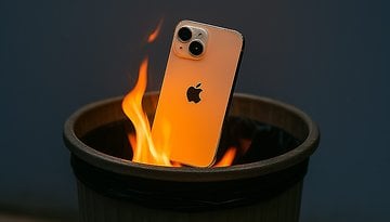 An iPhone partially submerged in flames inside a trash bin.