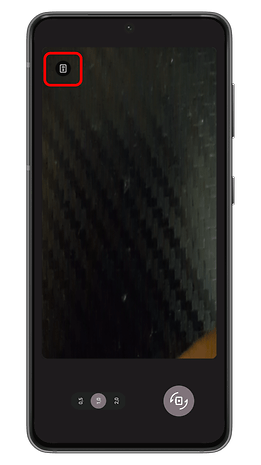 A smartphone screen displaying a camera interface with a button in the corner.