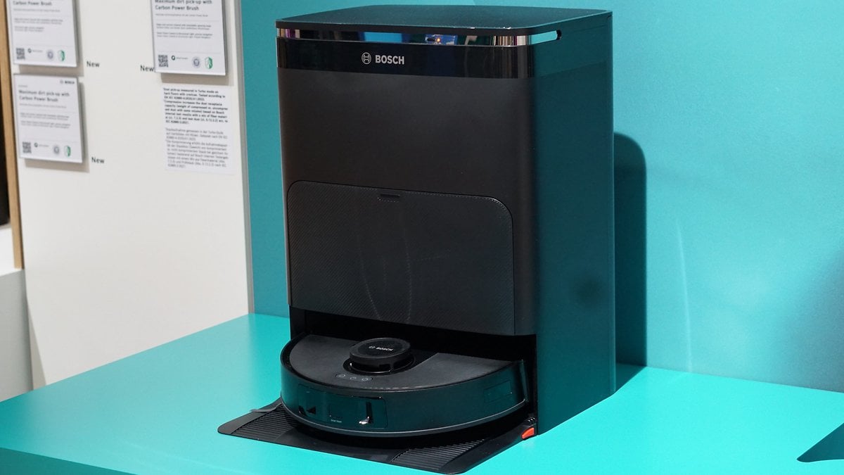 Bosch Spotless Roboterstaubsauger und Dockingstation auf einer türkisfarbenen Oberfläche.