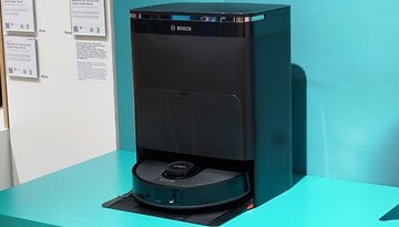 Bosch Spotless Roboterstaubsauger und Dockingstation auf einer türkisfarbenen Oberfläche.