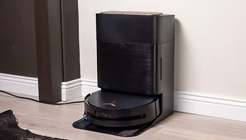 Ein schwarzer Ecovacs Deebot X9 Pro Omni-Roboterstaubsauger und seine Dockingstation in einem modernen Innenraum.