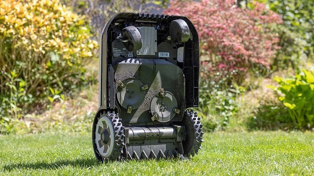 Ecovacs Goat A1600 RTK robotic lawn mower with its wheels on grass in a garden.