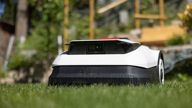 A white Ecovacs Goat A1600 RTK robotic lawn mower on green grass.