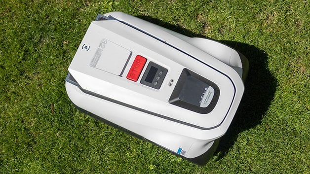 Ecovacs Goat A1600 RTK robotic lawn mower on grass, with its control buttons and display shown.