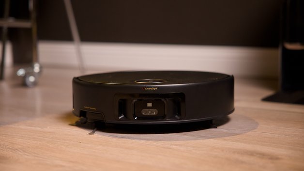 Schwarzer Roboterstaubsauger auf Holzboden, beschriftet mit 'AI Smart Sight'.