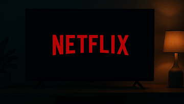 A dark room featuring a TV displaying the Netflix logo in red.