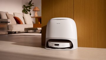 Roborock Qrevo CurvX-Roboterstaubsauger in einer eleganten weißen Ladestation in einem modernen Wohnzimmer.