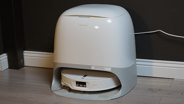 A Roborock Qrevo Curv 2 Pro robotic vacuum cleaner on a wooden floor.