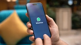 Uma mão segurando um smartphone exibindo o logotipo do WhatsApp na tela.