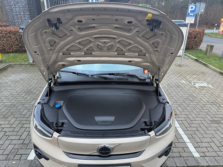 Capot ouvert d'une Volvo EX40, révélant le compartiment moteur avec un couvercle sombre et un capuchon bleu.