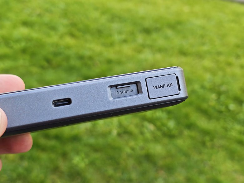 Eine Hand hält ein TP-Link M8550-Gerät mit USB- und WAN/LAN-Ports. Eine Hand hält ein TP-Link M8550-Gerät mit USB- und WAN/LAN-Ports.