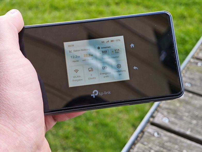 Eine Person hält ein TP-Link M8550-Gerät, das die Internetnutzung und den Verbindungsstatus anzeigt. Eine Person hält ein TP-Link M8550-Gerät, das die Internetnutzung und den Verbindungsstatus anzeigt.