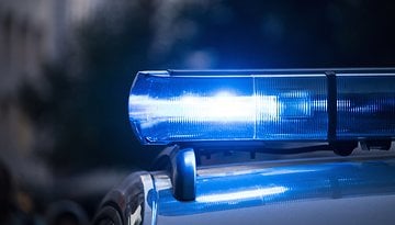 Nahaufnahme eines blinkenden blauen Lichts eines Polizeiautos.
