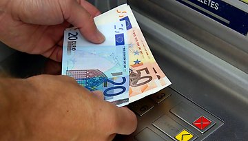 Euro-Scheine vor einem Geldautomaten