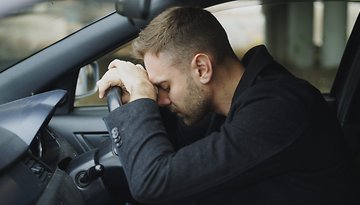 Autofahrer liegt mit dem Kopf auf dem Lenkrad