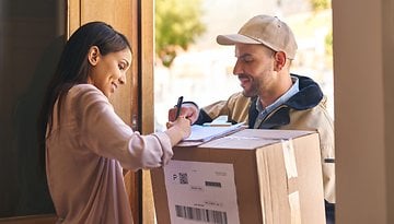 Postbote übergibt Paket an Frau