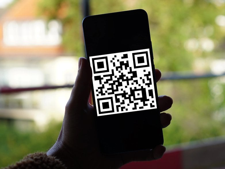 Smartphone mit QR-Code in einer Hand