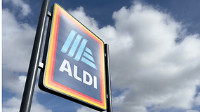 Aldi-Schild vor einem bewölkten Himmel.