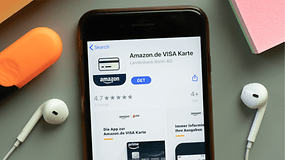 Ein Smartphone zeigt die Amazon.de VISA Karten-App mit einer Bewertung von 4,7 Sternen und Download-Optionen.