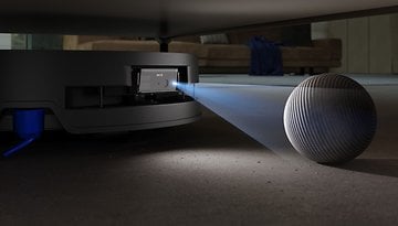 Nahaufnahme des Ecovacs Deebot X9 Pro Omni Saugroboters mit einer Laserprojektion und einem Ball daneben.
