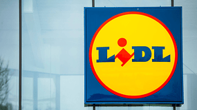 Lidl-Schild mit dem Logo auf gelbem Hintergrund und blauer Schrift.