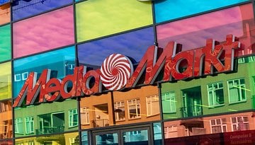 MediaMarkt-Logo auf einer bunten Glasfassade.