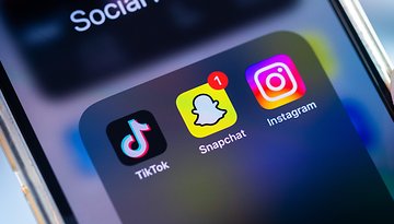 Ein Smartphone-Bildschirm zeigt soziale Medien-App-Symbole: TikTok, Snapchat und Instagram.