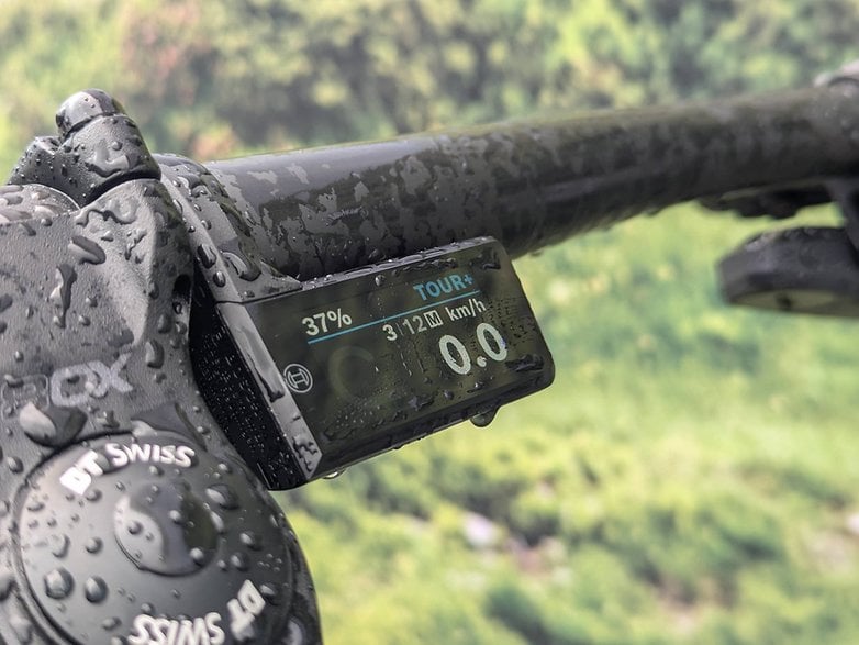 Purion 400 display showing battery at 37%, speed at 3.12 km/h, mounted on a bike handlebar with water droplets.